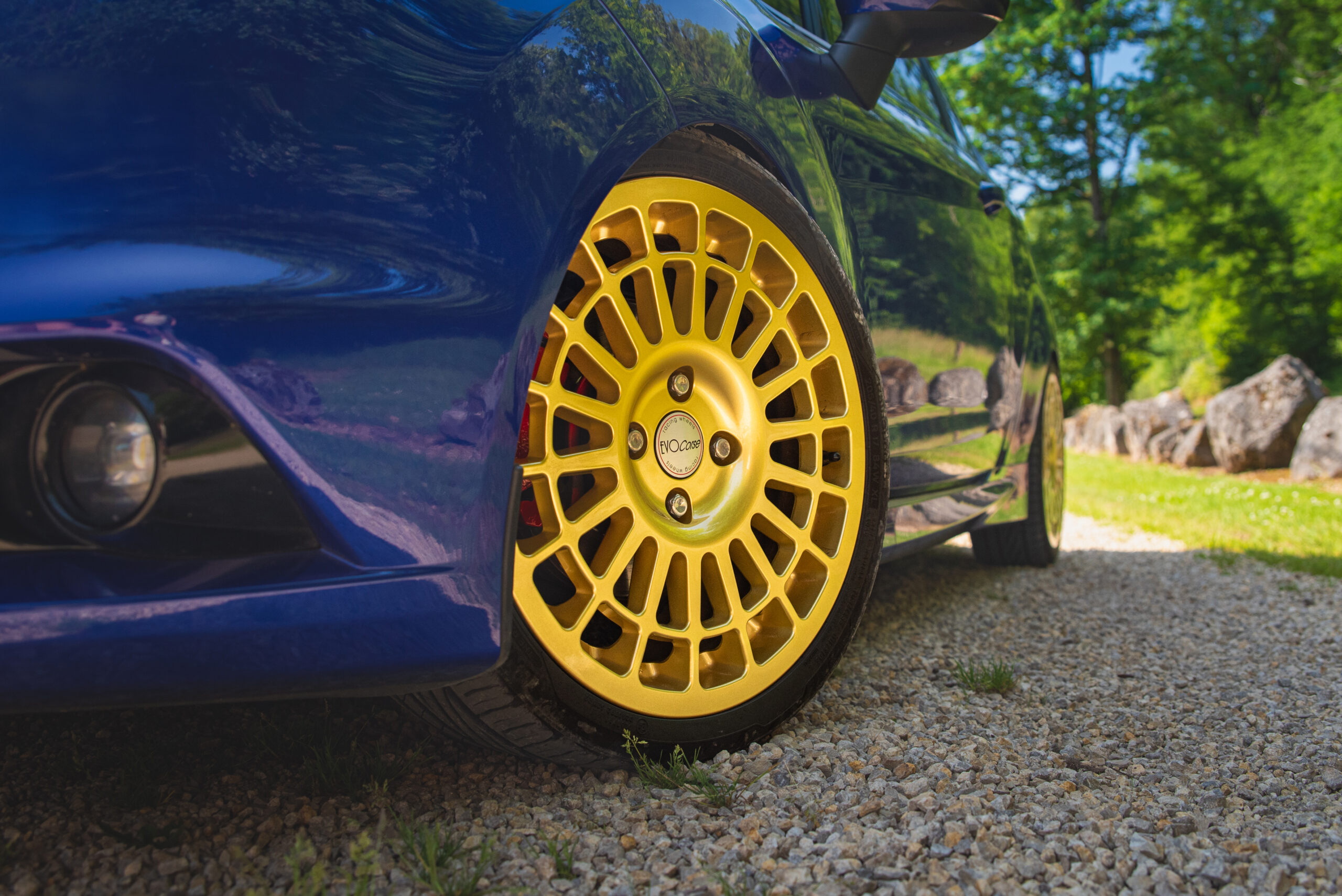 Gros plan sur la jante avant dorée d'une Ford Fiesta ST bleue. La jante est de type multi-rayons et on aperçoit l'étrier de frein rouge derrière elle.